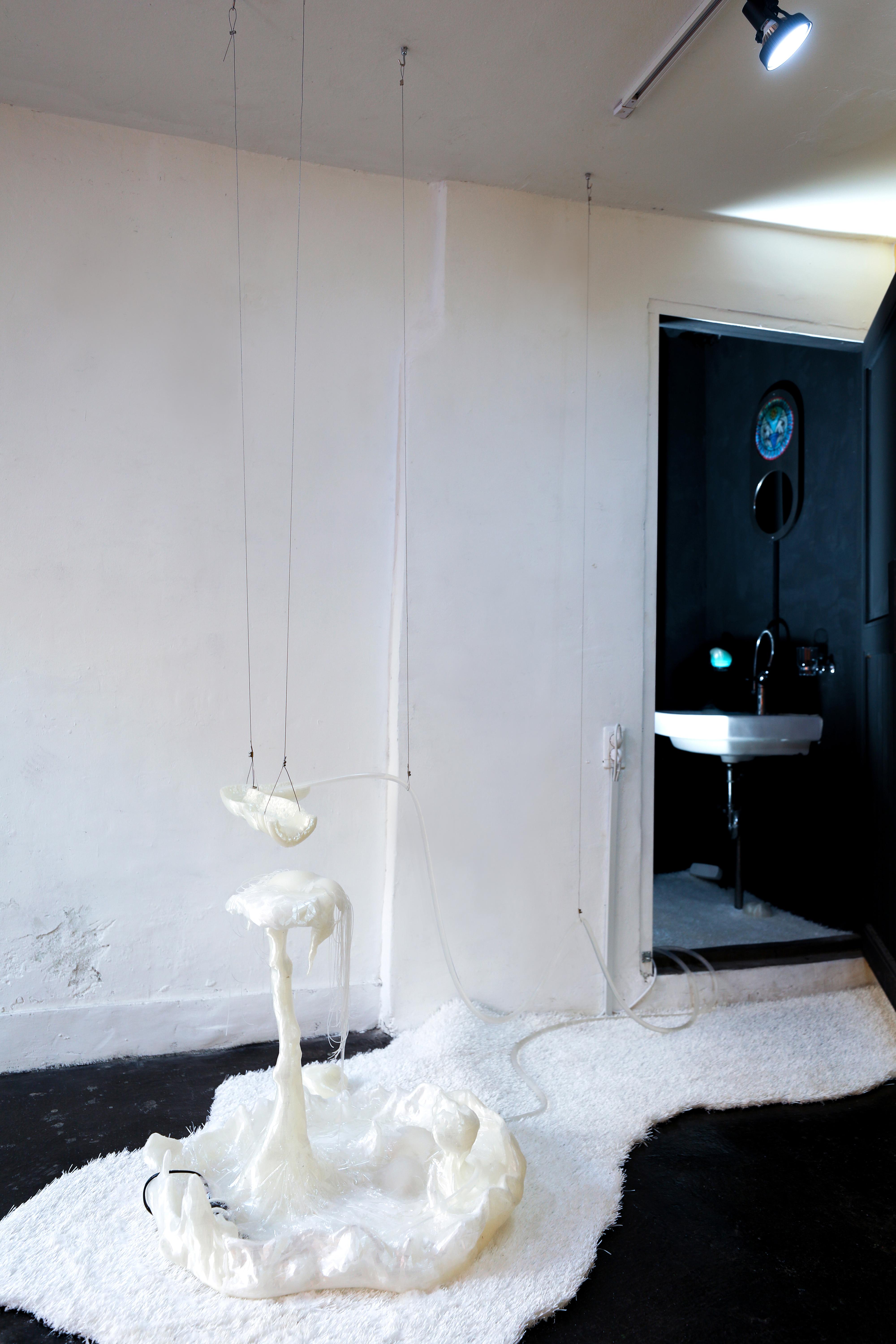 the outside of a bathroom with a gloopy wax sculpture